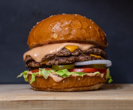 stacked cheeseburger on wooden board