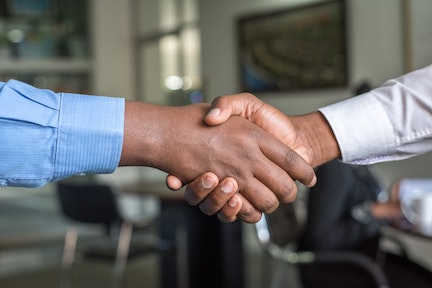 two people shaking hands close up

