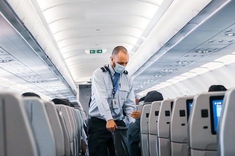 flight attendant in aisle on plane