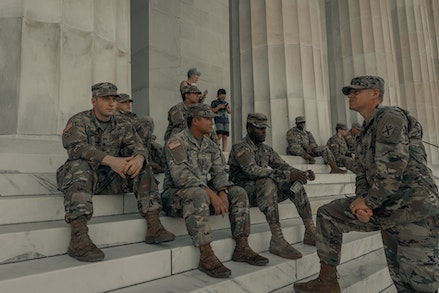 servicemen sitting on steps