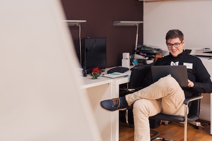 person on chair using laptop