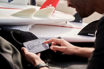 person signing name on smartphone
